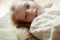 Jeune fille couchée sur le dos, souriant — Photo de stock