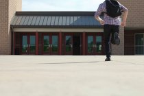 Estudante do ensino médio masculino correndo em direção à escola — Fotografia de Stock