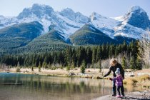 Бабуся й внучка коло ріки, Три сестри, Скелясті гори, Канмор, Альберта, Канада — стокове фото
