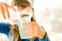 Menina fazendo experiência científica, derramando líquido — Fotografia de Stock