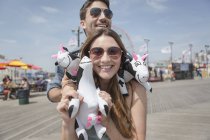 Zeitgenössisches Paar amüsiert sich auf Vergnügungspark-Promenade mit Blow-up-Preisen — Stockfoto