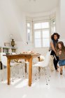 Woman playing with daughter in kitchen — Stock Photo