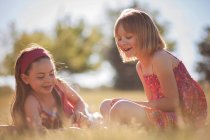 Smiling girls playing in grass — Stock Photo