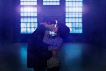 Paar küsst sich in leerer Lagerhalle — Stockfoto