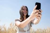 Femme prenant des photos avec téléphone portable — Photo de stock