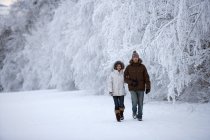 Пара, гуляющая по снегу. — стоковое фото