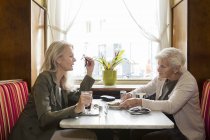 Mother and daughter sitting together in cafe — Stock Photo