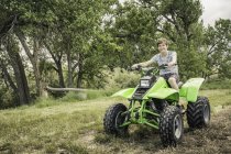 Portrait of young man riding quad bike in field — Stock Photo