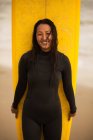 Porträt einer jungen Frau mit Surfbrett — Stockfoto