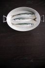 Tres peces frescos en un plato en la mesa - foto de stock