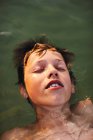 Teenage boy floating in water — Stock Photo