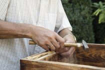 Uomo anziano che fa cassa di legno in giardino, sezione centrale — Foto stock
