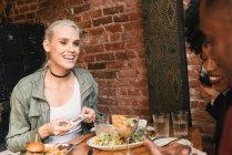 Multikulturelle Freunde beim gemeinsamen Essen im Café — Stockfoto