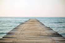Empty wooden pier and blurred seascape — Stock Photo