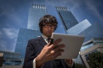 Young businessman using table outside office buildings — Stock Photo