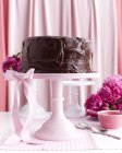 Schokoladenkuchen auf rosa Ständer — Stockfoto