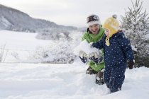 Père et fils jouant dans la neige dans le paysage rural — Photo de stock