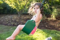 Girl swinging on garden swing — Stock Photo