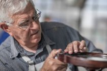 Cape Town, South Africa, elderly craftsman adjusting glue to fit tabl — Stock Photo