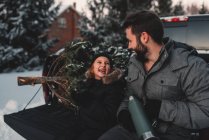 Vater und Tochter auf dem Rücksitz eines Pick-ups mit Weihnachtsbaum — Stockfoto