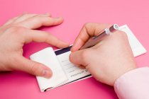 Cropped image of Man signing cheque book — Stock Photo