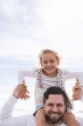 Портрет зрілої людини, що дає дочці плече носіння на узбережжі — стокове фото