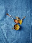 Cucchiai pieni di spezie su sfondo di stoffa blu — Foto stock