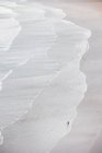 Вид з повітря на пляж з хвилями і людиною з дошкою для серфінгу — стокове фото