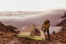 Male hiker putting up tent above the clouds, Mineral King, Sequoia National Park, California, USA — Stock Photo