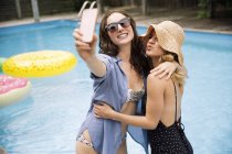 Femmes prenant selfie avec téléphone portable près de la piscine, Amagansett, New York, USA — Photo de stock