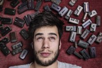 Young man with letterpress letters surrounding his head — Stock Photo
