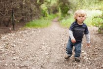 Хлопчик ходить на брудній доріжці — стокове фото