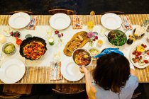 Женщина кладет блюдо на обеденный стол — стоковое фото