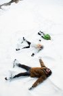 Family making snow angels — Stock Photo