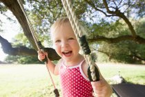 Porträt einer Kleinkindfrau auf Baumschaukel — Stockfoto