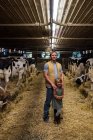 Retrato de agricultor e hija en cobertizo de vaca - foto de stock