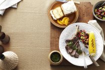 Вечеря з тарілкою стейк, кукурудза, салат з бобів нирки та сальса Верде — стокове фото