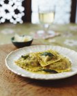 Plate of ravioli with butter, pepper, herbs and parmesan — Stock Photo