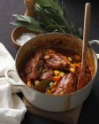 Pan of lamb shanks with zucchini, carrot, beans and bay leaves — Stock Photo