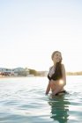 Donna che cammina in acqua sulla spiaggia — Foto stock
