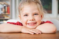 Smiling girl resting on elbows — Stock Photo