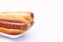 Due hot dog con salsicce alla griglia sul piatto — Foto stock