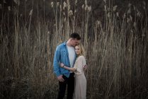 Couple hugging and kissing, tall grass field in background, Ottawa, Ontario — Stock Photo