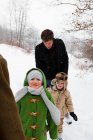 Famiglia che cammina nella neve insieme all'aperto — Foto stock