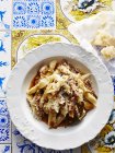 Still life with bowl of italian rabbit garganelli and parmesan — Stock Photo