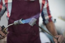 Mittelteil des Mannes erhitzt Branding Iron mit Blasbrenner in Fabrik — Stockfoto