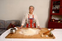 Older woman baking in living room — Stock Photo