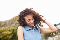 Young woman with hand in hair, smiling — Stock Photo