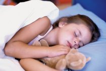 Mädchen schläft mit Teddybär — Stockfoto