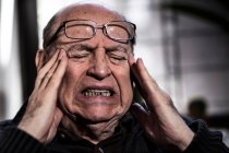 Старший чоловік з закритими очима, одягнений в окуляри, дивлячись на стрес — стокове фото